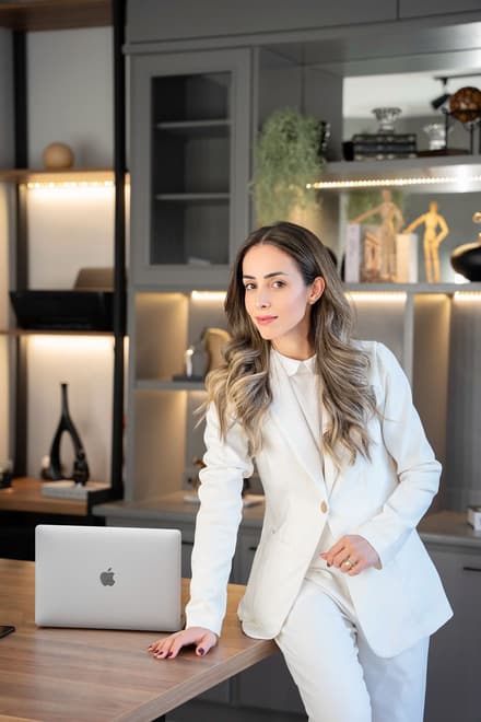 Adriana Gomes, dona de estúdio de pilates, apoiada em sua mesa de trabalho